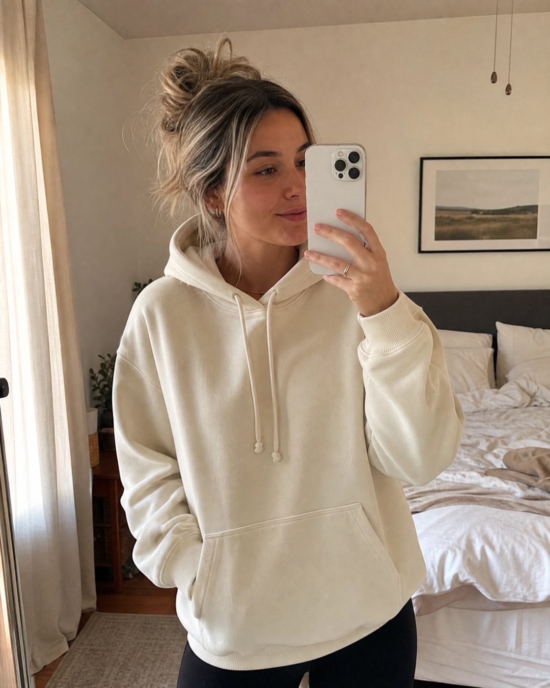 AI-generated mirror selfie of a model wearing the cream hoodie